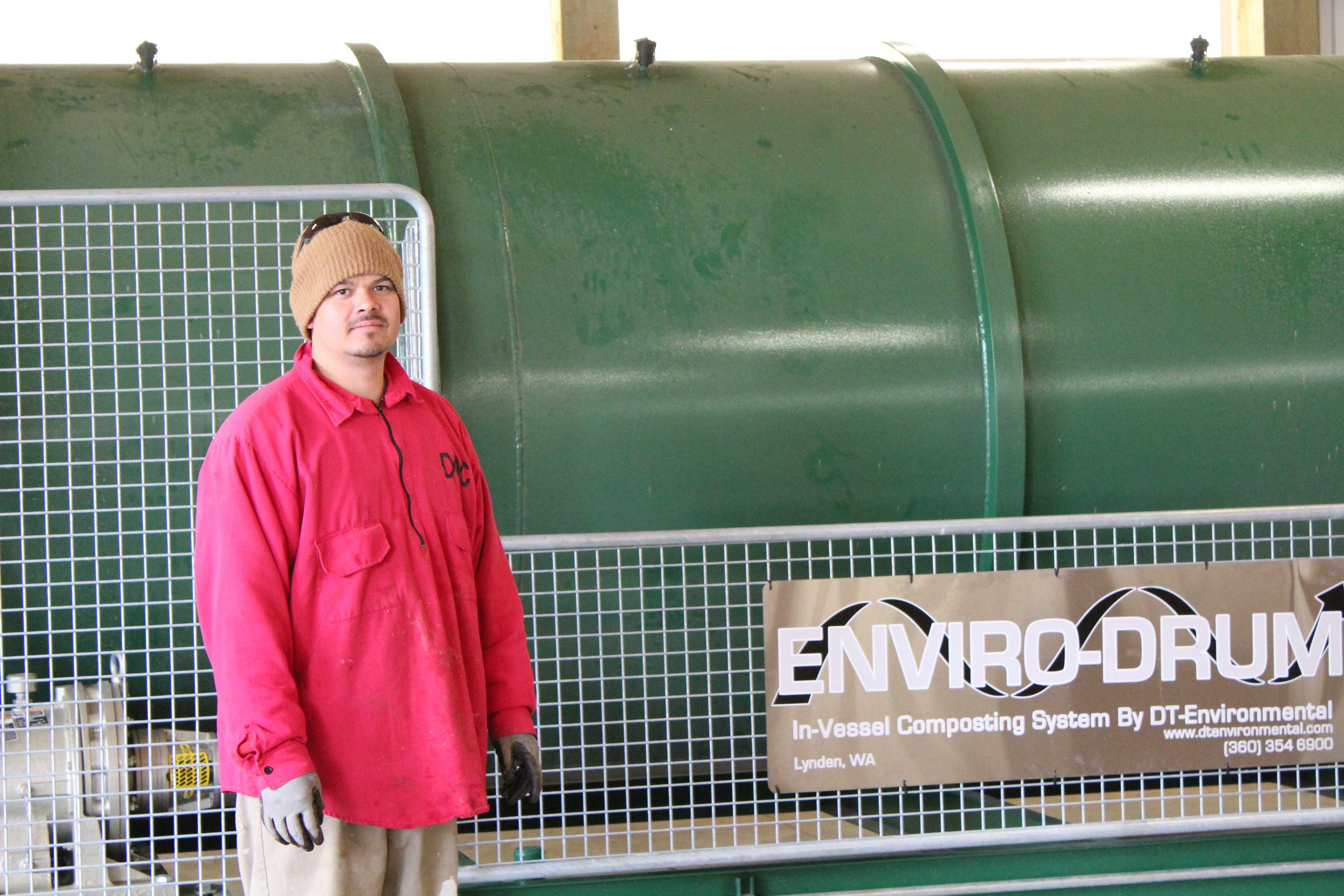 An inmate technician for CCCC's large-scale composting program was pleased to pose with the new machine.