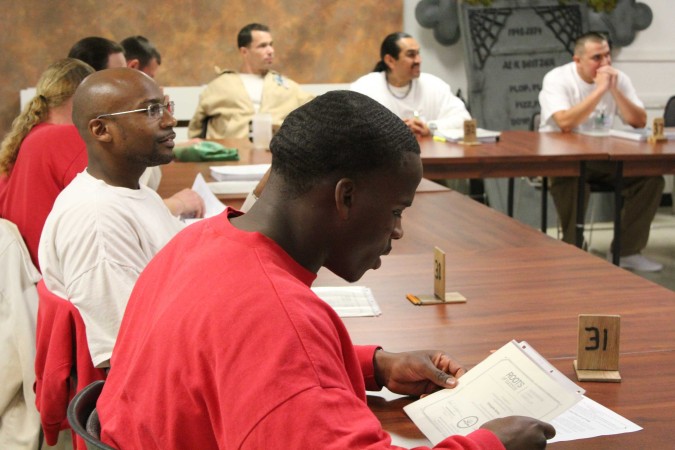 One of the Roots graduates reads his graduation certificate. Photo by Joslyn Rose Trivett.