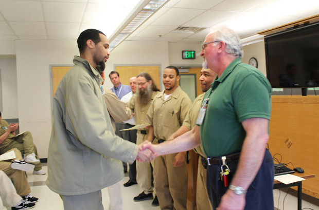 Thirty five graduates of Roots of Success receive their certificates and handshakes from Mr. Aleksinski, the three inmate instructors, Superintendent Glebe, SPP Liaison Chris Idso, and SPP Ecological Conservation Nursery Coordinator for SCCC Drissia Ras. 