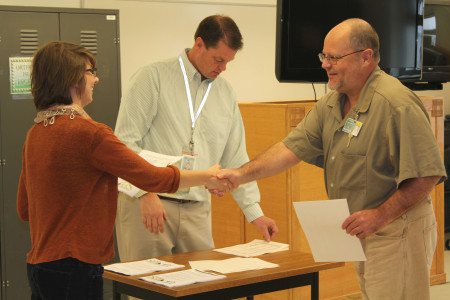 Tiffany Webb congratulates a lecture series certificate recipient.