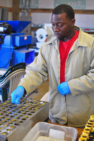 A crew member covers sown seeds with a gravel cover; a gravel cover reduces moss competition and keeps light seed from floating to the surface.