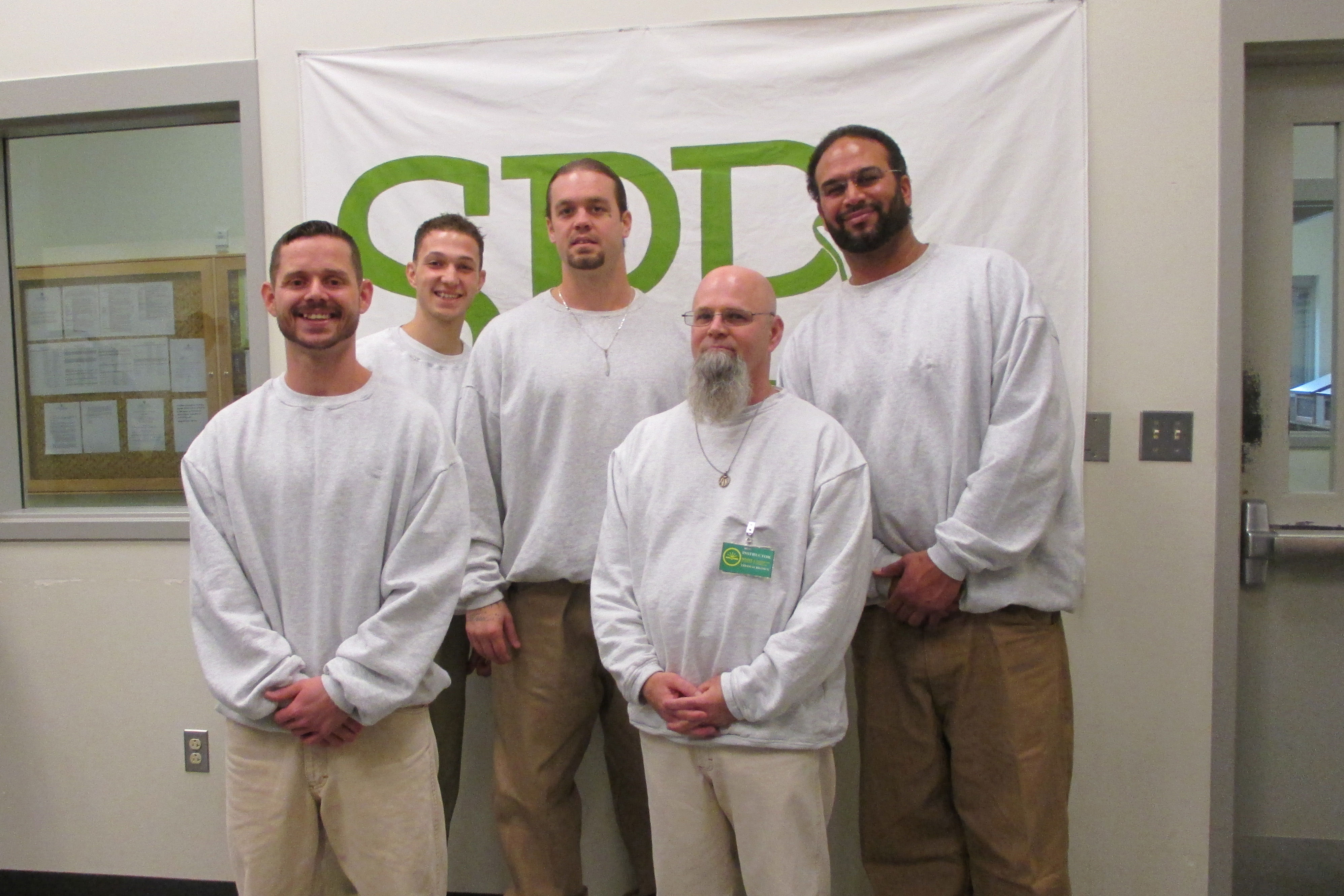 Thomas Brown, Derrick Martin-Armstead, Jason McDaniels, Jay Powell, and Eugene Youngblood, CRCC's Roots of Success Instructor staff, stand in front of their new SPP banner. Photo by Joslyn Rose Trivett