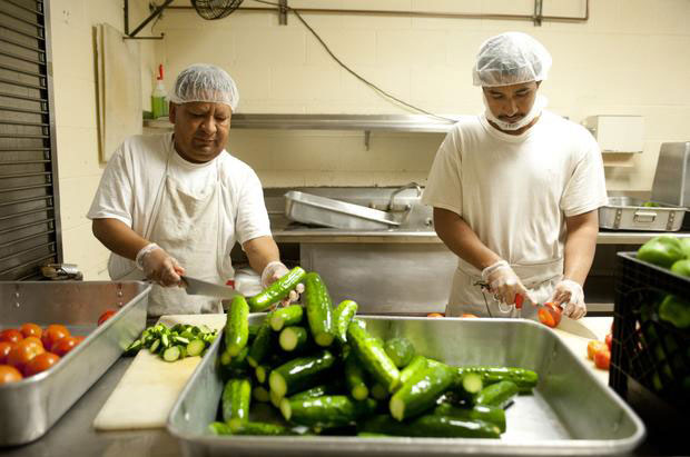 Inmates in the kitchen process vegetables grown on-site, and on their way to the prison menu.