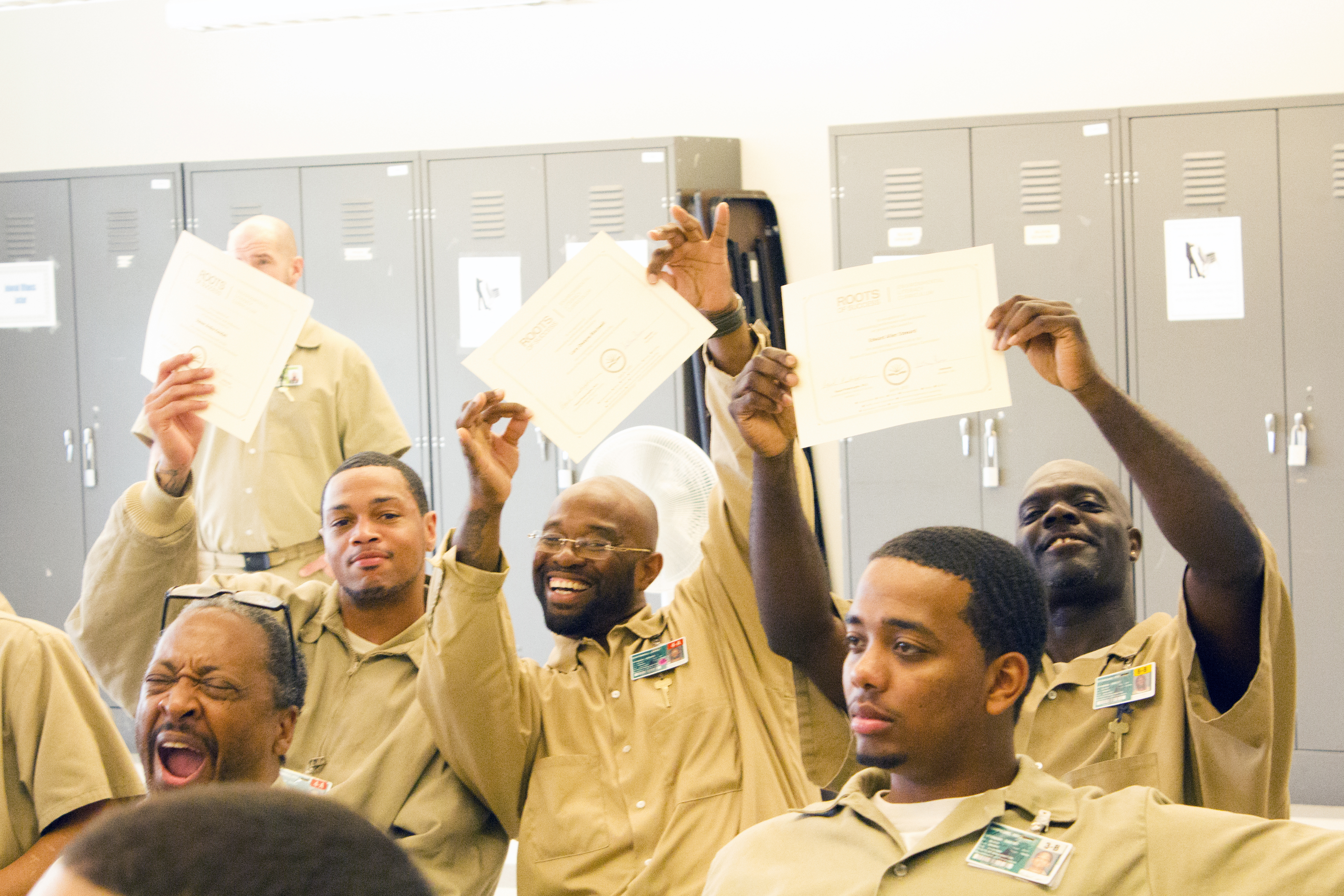 Recent Roots of Success graduates proudly display their certificates